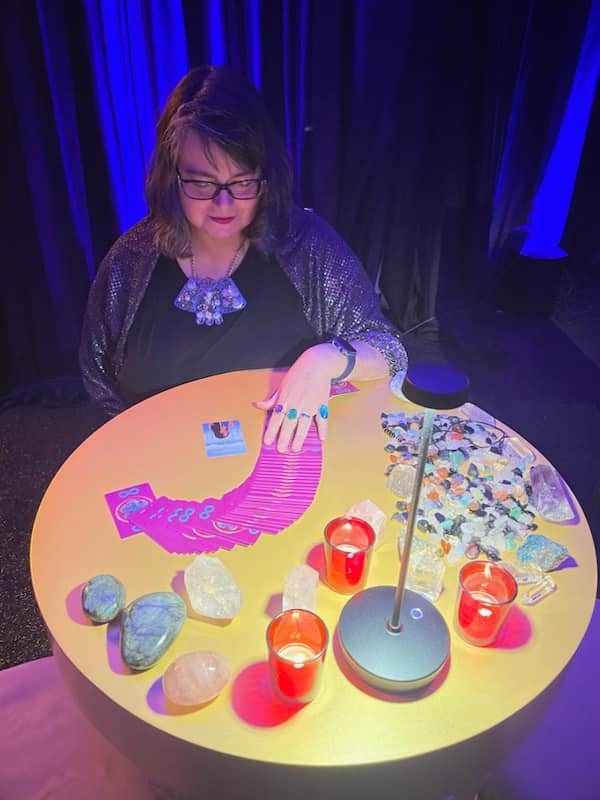 izolda at a gold table reading tarot