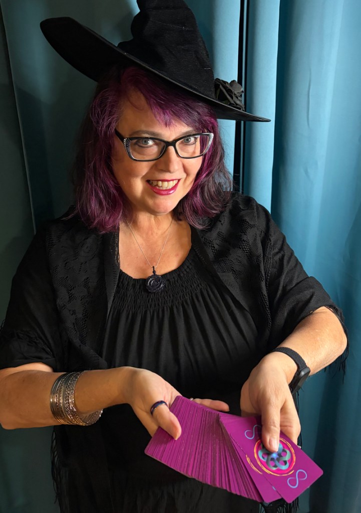 black witches hat holding cards